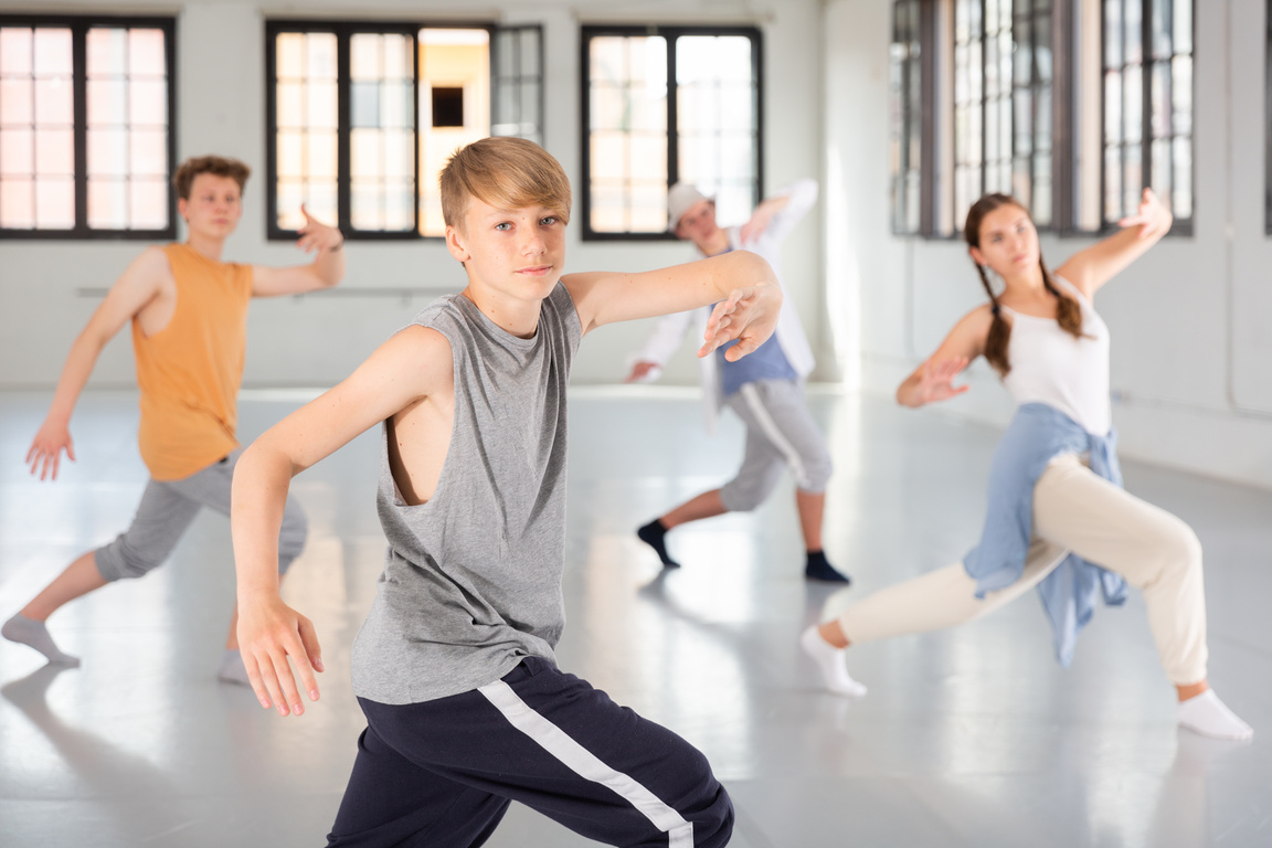 Group teenagers dancing hip-hop indoors